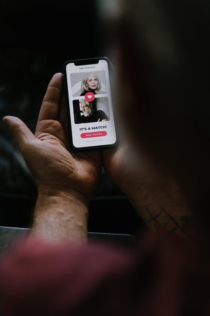 Human Hands Holding a Smartphone with Dating-Matching App on Screen